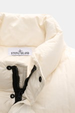Stone Island Down jacket 'Garment Dyed Crinkle Reps NY' cream close-up from front top view showing high-closing collar, zipper, snap buttons, and durable crinkle microfiber fabric with wind and water repellent coating. Innovative garment-dyed look, warm d