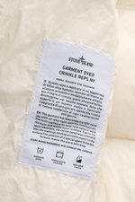 Close-up of the label inside the Stone Island Down jacket 'Garment Dyed Crinkle Reps NY' cream, photographed from a front interior perspective.

Description: <p>Innovative coated material in a signature garment-dyed look meets modern outdoor style in the 
