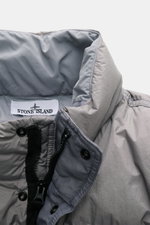 Stone Island Down jacket 'Garment Dyed Crinkle Reps NY' grey shown close-up from above, highlighting collar, YKK zipper, and label; innovative coated microfibre with crinkle look, garment-dyed, water/wind repellent, warm down lining, regular fit, storm fl