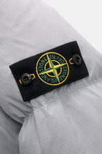 Close-up front-side view of Stone Island Down Jacket 'Matt Ripstop Cordura' Smoky Blue showing black compass badge on durable ripstop fabric.

Technical performance in urban design: The down jacket 'Matt Ripstop Cordura' from STONE ISLAND impresses with r