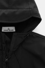 Nahaufnahme des Stone Island Softshell-Blouson 'Light Soft Shell-R e.dye Technology' schwarz von oben, zeigt Kapuze mit Tunnelzug, robusten Reißverschluss und glatte, wind- und wasserabweisende Microfaser.