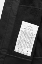 Nahaufnahme des Innenfutters vom Stone Island Softshell-Blouson 'Light Soft Shell-R e.dye Technology' schwarz, Detailansicht des Mesh-Innenfutters, des Etiketts und der komfortablen Rippbündchen, wind- und wasserabweisend, atmungsaktiv, Slim Fit.