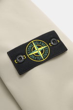 Stone Island Softshell-Blouson 'Light Soft Shell-R e.dye Technology' sand, Detailaufnahme des Kompass-Badges auf elastischer Microfaser, glatter Griff, wind- und wasserabweisend.