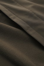 Nahaufnahme des graubraunen Stone Island Softshell-Blouson 'Light Soft Shell-R e.dye Technology' mit elastischer Microfaser, wind- und wasserabweisendem Material und Mesh-Innenfutter, Detailansicht der glatten Oberfläche und feinen Naht, Blick aus nächste