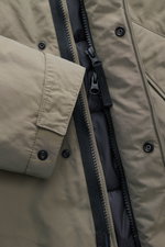 Nahaufnahme der Stone Island Jacke 'Micro Reps' graugrün, Slim Fit aus Baumwoll-Canvas mit weichem Griff, Zwei-Wege-Reißverschluss, Knöpfen, wattierter Kapuze, schrägen Taschen und Kompass-Badge.