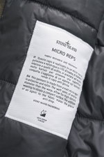 Nahaufnahme des weißen Labels in der Innenseite der Stone Island Jacke 'Micro Reps' khaki mit Popeline, Slim Fit, wattierter Kapuze und Primaloft-Wattierung.