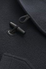 Nahaufnahme der dunkelblauen Stone Island Jacke 'Heavy Melton' navy mit griffigem Woll-Cashmere-Gewebe und Knebelverschluss im Dufflecoat-Stil.