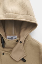 Stone Island Jacke 'Heavy Melton' beige in Nahaufnahme von oben, Kapuze mit doppeltem Köper aus Wolle und Kaschmir, Knebelknöpfe, Kompass-Badge sichtbar.