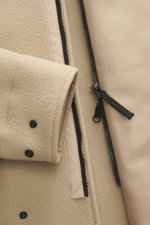 Nahaufnahme der Stone Island Jacke 'Heavy Melton' beige, mit Fokus auf den Reißverschluss, Knöpfen und Woll-Kaschmir-Material.