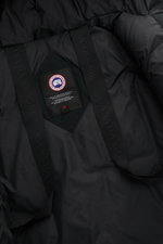 Nahaufnahme innen vom Canada Goose Daunenparka 'Langford' schwarz mit Arctic-Tech-Material, Daunenfüllung, Rucksackriemen, Weblabel und Etikett.