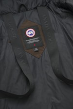 Canada Goose Daunenparka 'Langford' dunkelbraun, Detailaufnahme von innen mit Arctic-Tech-Material, Rucksackriemen und Logo-Patch.