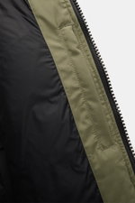 Close-up inside view of the Canada Goose Down parka 'Langford' grey green showing the black warm down lining and Arctic-Tech fabric with zipper edge from a top-down perspective. Urban style with an arctic background – the down parka 'Langford' by CANADA G