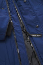Close-up front view of the Canada Goose Down parka 'Langford' dark blue, showing the black YKK two-way zipper, snap buttons, and fabric texture. Urban style with an arctic background – the down parka 'Langford' by CANADA GOOSE impresses with its clear, fu