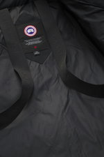 Canada Goose Down jacket 'Wyndham' black interior shown from above, featuring mix of high-quality microfiber and cotton, smooth feel, warm down filling, slim fit, high-closing two-way zipper, wind flap with snap buttons, padded hood with drawstring, four 