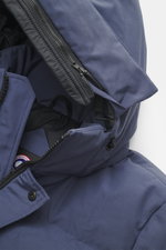 Close-up view of the Canada Goose Down jacket 'Wyndham' grey blue, showing the padded hood, high-closing two-way zipper, wind flap with snap buttons, and smooth microfiber and cotton fabric. Features include warm down filling, slim fit, four welt pockets 
