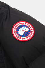 Close-up side view of the Canada Goose Down jacket 'Sterling' black, showing the typical woven label on the upper arm made of high-quality microfiber with smooth touch, water-repellent finish, warm down filling, oversized fit, high-closing two-way zipper,