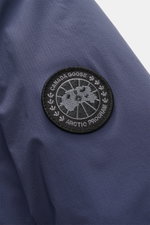Close-up front-side view of the Canada Goose Down Jacket 'Lodge Hoody' Dark Blue showing the black woven Arctic Program label on ripstop microfiber fabric.

<p>Maximum comfort in a lightweight design: The packable down jacket 'Lodge Hoody' by CANADA GOOSE