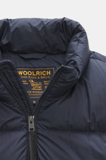 Close-up front view of the Woolrich Down jacket dark blue showing high-quality microfiber with smooth feel, warm down filling, slim fit, durable two-way zipper, piped front pockets, adjustable hem, quilted lining fabric, and two inner pockets.