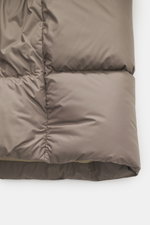 Nahaufnahme der Woolrich Daunenjacke taupe von unten, zeigt hochwertige Microfaser, wärmende Daunenfüllung, Slim Fit, paspelierte Taschen, robuster Zwei-Wege-Reißverschluss, regulierbaren Saum, gesteppter Futterstoff und zwei Innentaschen.