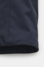 Nahaufnahme des unteren Bereichs des Woolrich Daunenparka 'Stretch Arctic' navy, seitliche Perspektive, hochwertige Microfaser, weicher Griff, wind- und wasserabweisend, leichte Daunenfüllung, Slim Fit, robuster Zwei-Wege-Reißverschluss, Windblende mit Kn