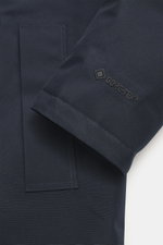 Close-up image of the Woolrich Down jacket 'Heavy GTX' navy sleeve and pocket from a side angle, featuring high-quality microfiber, wind- and water-repellent fabric, warm down filling, slim fit, robust two-way zipper, wind flap with buttons, high-closing 
