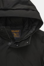 Close-up front view of Woolrich Down jacket 'Heavy GTX' black, showing high-closing collar with hood, robust two-way zipper, wind flap with buttons, and quilted lining fabric; features high-quality microfiber, wind- and water-repellent, warm down filling,