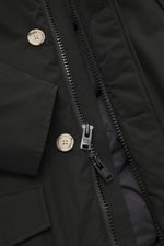 Close-up front view of Woolrich Down parka 'Arctic Parka' black showing zipper, buttons, and fabric texture; cotton-microfibre blend, warm down lining, wind- and water-repellent, slim fit, two-way zip, storm flap with buttons, flexible down-lined hood, co