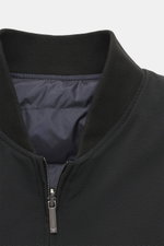 Nahaufnahme des Kragens und oberen Frontbereichs des Emporio Armani Daunen-Wendeblouson navy, fotografiert von vorne, mit hochwertiger Microfaser, weichem Griff, leichter Daunenfüllung, wendbar, Regular Fit, robustem Zwei-Wege-Reißverschluss, klassischem 