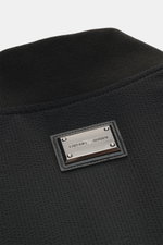 Nahaufnahme des klassisch schwarzen Kragens mit Emporio Armani Metall-Logo am Emporio Armani Daunen-Wendeblouson navy, hochwertige Microfaser, weicher Griff, leichte Daunenfüllung, wendbar, Regular Fit, robuster Zwei-Wege-Reißverschluss, klassischer Blous