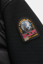 Nahaufnahme der rechten Ärmelpartie der Parajumpers Daunenjacke 'Jayden' schwarz, Detail des elastischen Wabengewebes und PJS-Weblabels, hochwertige Microfaser.