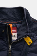 Nahaufnahme der Parajumpers Daunenjacke 'Jayden' navy von oben, zeigt hochwertigen Microfaser-Stoff, elastisches Wabengewebe an Kragen und Ärmeln, glatten Griff, robusten Zwei-Wege-Reißverschluss mit gelbem Riemen, PARAJUMPERS-Weblabel am Oberarm, atmungs