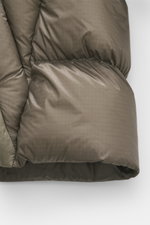 Nahaufnahme der wattierten Oberfläche der Parajumpers Daunenjacke 'Notigi' khaki aus ultraleichtem Nylon-Ripstop, Detailaufnahme von unten, betont wärmende Daunenfüllung und Microfaserstruktur.