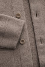 Nahaufnahme des 04651/ A trip in a bag Cardigan 'Boiled Blouson' taupe aus reiner Wolle mit Umlegekragen, sechs Knöpfen und Rippbündchen.
