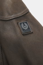 Close-up front detail of the Belstaff Leather Jacket 'Gangster' Brown showing noble nubuck leather and logo patch, shot from a top angle. For a cool look since 1969: The leather jacket 'Gangster' by the biker label BELSTAFF is an icon that ensures an opti