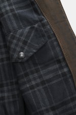 Close-up inside view of the Belstaff Leather Jacket 'Gangster' Brown showing checkered lining fabric, inside pocket flap with Belstaff snap button, and brown nubuck leather edge, photographed from the interior perspective. For a cool look since 1969: The 