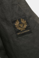 Close-up front view of Belstaff Wax blouson 'Mount Jacket' dark olive showing the black and gold BELSTAFF woven label on waxed cotton.

Description: <p>The robust blouson 'Mount Jacket' by BELSTAFF combines military aesthetics with British motorcycle trad
