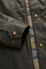 Belstaff Waxed Jacket 'Ground' dark olive close-up from front showing waxed cotton, smooth feel, robust metal zipper, wind flap with press studs, turn-down collar with corduroy trim, patch chest pocket with press studs, BELSTAFF woven label on upper arm, 
