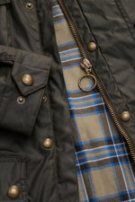Belstaff Wachsjacke 'Trialmaster' dark olive, Detailaufnahme von innen mit gewachster, wasserabweisender Baumwolle, Reißverschluss mit Ring, Druckknöpfen, Cordbesatz und kariertem Innenfutter.