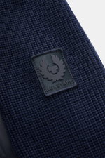 Close-up front view of the Belstaff Down knit jacket 'Compound' navy showing soft patent pure wool knit, medium-fine pattern, and Belstaff logo patch.

Description: <p>Soft patent knit made of pure wool, combined with a pleasantly light down quilted front