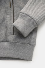 Nahaufnahme des Moorer Daunenblouson 'Levion' grau meliert von schräg oben, zeigt weichen Griff, Slim Fit, zwei Innentaschen, Zipper-Fronttaschen, elastische Saum- und Ärmelabschlüsse, Windblende mit Knöpfen, schmalen Stehkragen mit abnehmbarem Lammfellbe