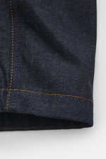 Close-up view of the sleeve hem and detailed stitching of the Stone Island Denim jacket 'Indigo Denim-Raw' navy, showcasing raw denim fabric.