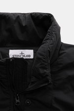 Close-up front view of the Stone Island Down Jacket 'Seamless Tunnel Nylon Down-TC' black collar showing high-quality microfiber, smooth touch, and zipper.