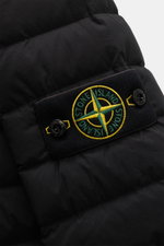 Close-up front view of the Stone Island Down Jacket 'Seamless Tunnel Nylon Down-TC' black showcasing the compass badge on high-quality microfiber fabric with smooth touch, lightweight duck down filling, garment dyed, and slightly elastic quality. The jack