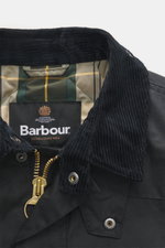Close-up front view of Barbour Wachsjacke 'Reelin Wax' dark olive with cord collar, gold zipper, and tartan lining, showcasing classic British countryside style.