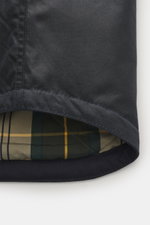 Close-up view from the inside hem of the Barbour Wachsjacke 'Reelin Wax' dark olive, showing waxed cotton exterior and tartan lining.