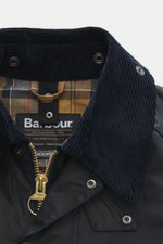 Close-up view of the dark navy corduroy collar and tartan lining of the Barbour Wax jacket 'Beaufort' from the front top perspective.

Description:  
<p>True classic from BARBOUR: The long-cut wax jacket 'Beaufort' made of water-repellent, waxed cotton wi