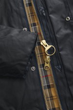 Close-up front view of Barbour Wax jacket 'Beaufort' dark navy showing water-repellent waxed cotton, gold two-way zipper, corduroy collar, snap buttons, and tartan lining.

<p>True classic from BARBOUR: The long-cut wax jacket 'Beaufort' made of water-rep