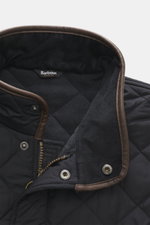 Close-up top view of Barbour Quilted jacket 'Powell Quilt' navy collar showing fleece lining, faux leather trim, zipper, and snap buttons. 

<p>Styled after the popular Chelsea design, the 'Powell Quilt' quilted jacket features light padding and a fleece 