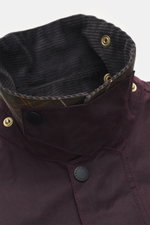 Close-up front view of Barbour Wax jacket 'Beaufort Icons' purple showing corduroy-trimmed turn-down collar, snap buttons, and tartan lining.