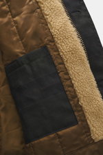 Close-up view of the interior of the Barbour Wax parka 'Ursula' dark navy, showing waxed cotton typical material texture, quilted lining, and inner pocket with water-repellent, breathable fabric, double front, regular fit, robust two-way zipper, smooth bu